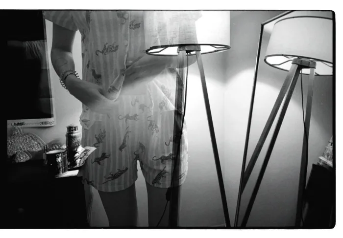 Translucent holographic woman in pajamas in front of a lamp next to a mirror